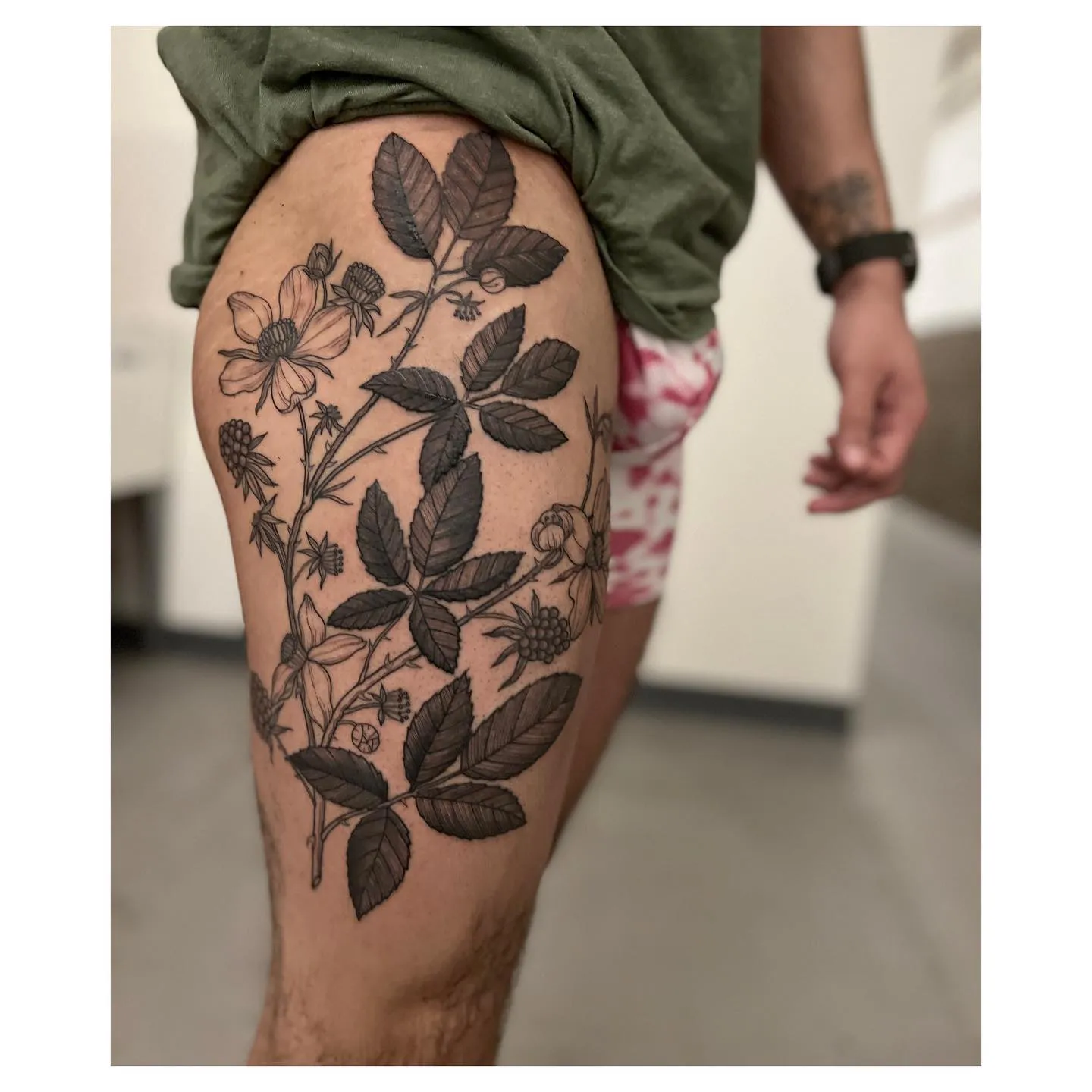 Blackberry vine tattoo wrapping thigh