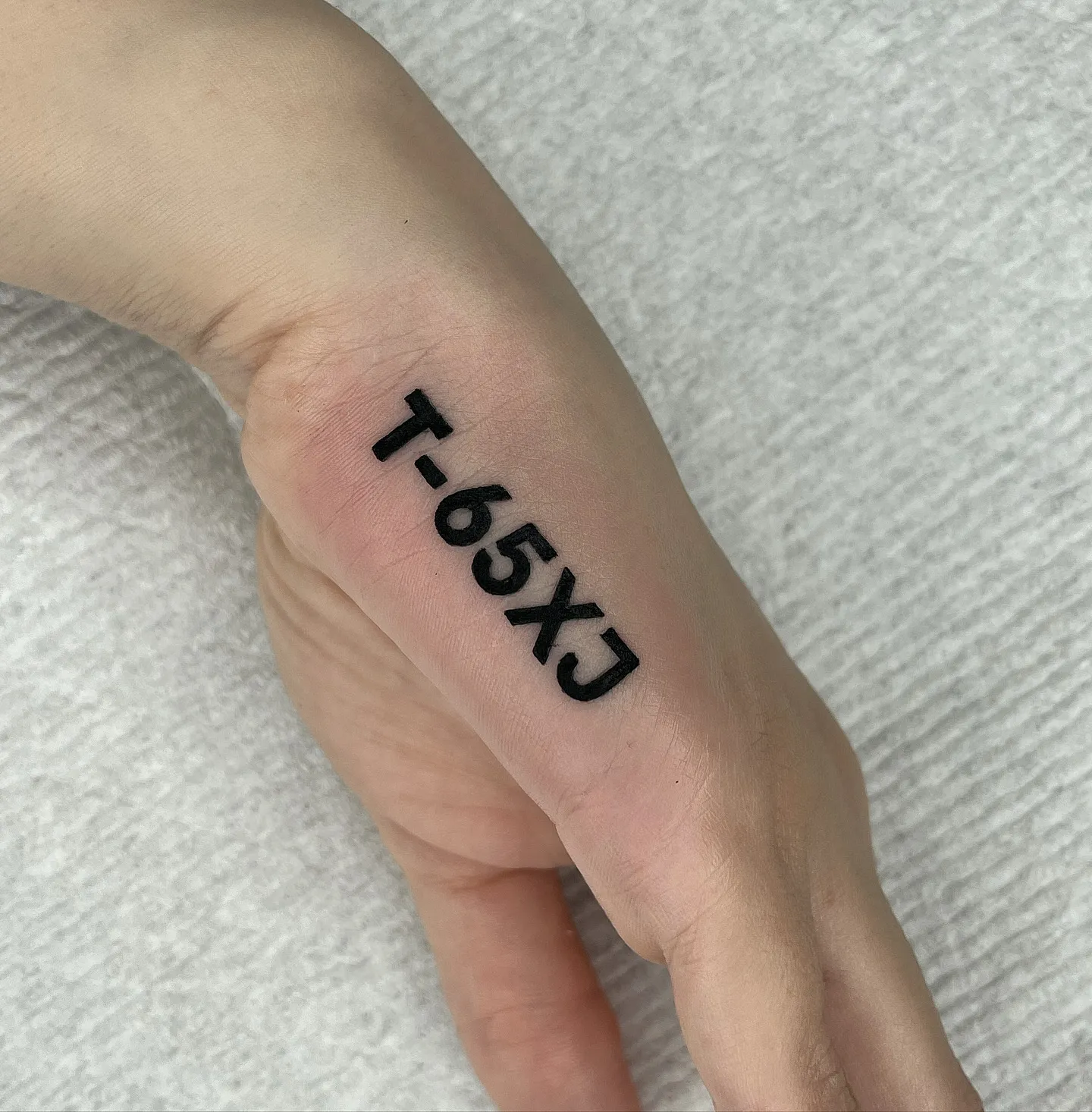Bold Black Lettering Tattoo for Side Hand