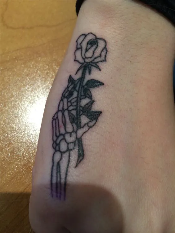 Classic rose with skull side of hand tattoo