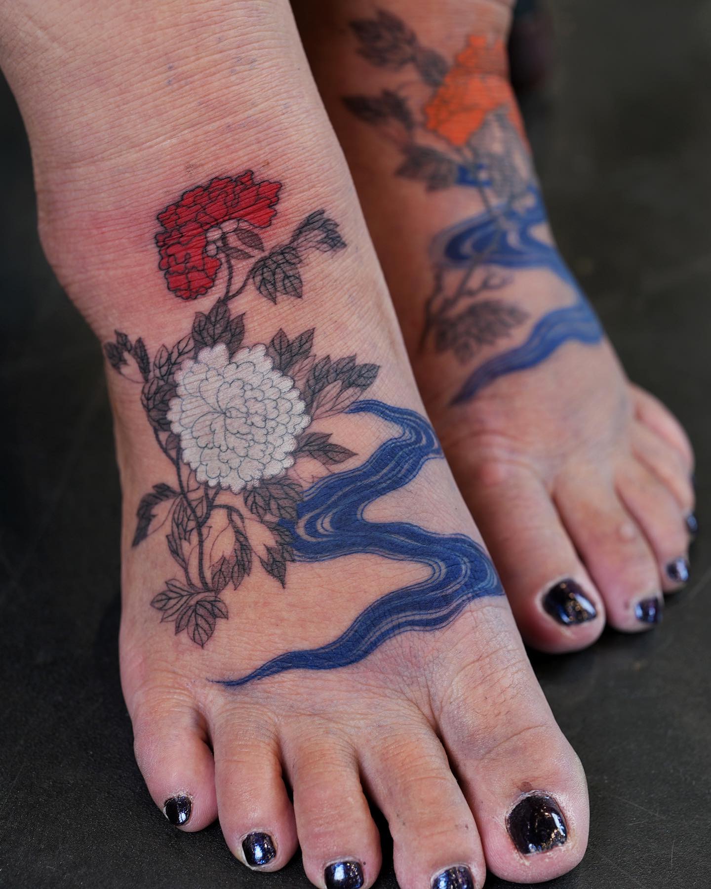 Elegant floral foot tattoos with vibrant colors