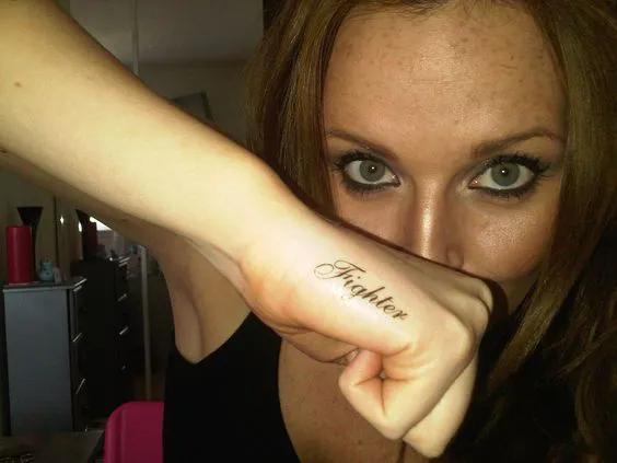Inspirational word tattoo on the side of hand