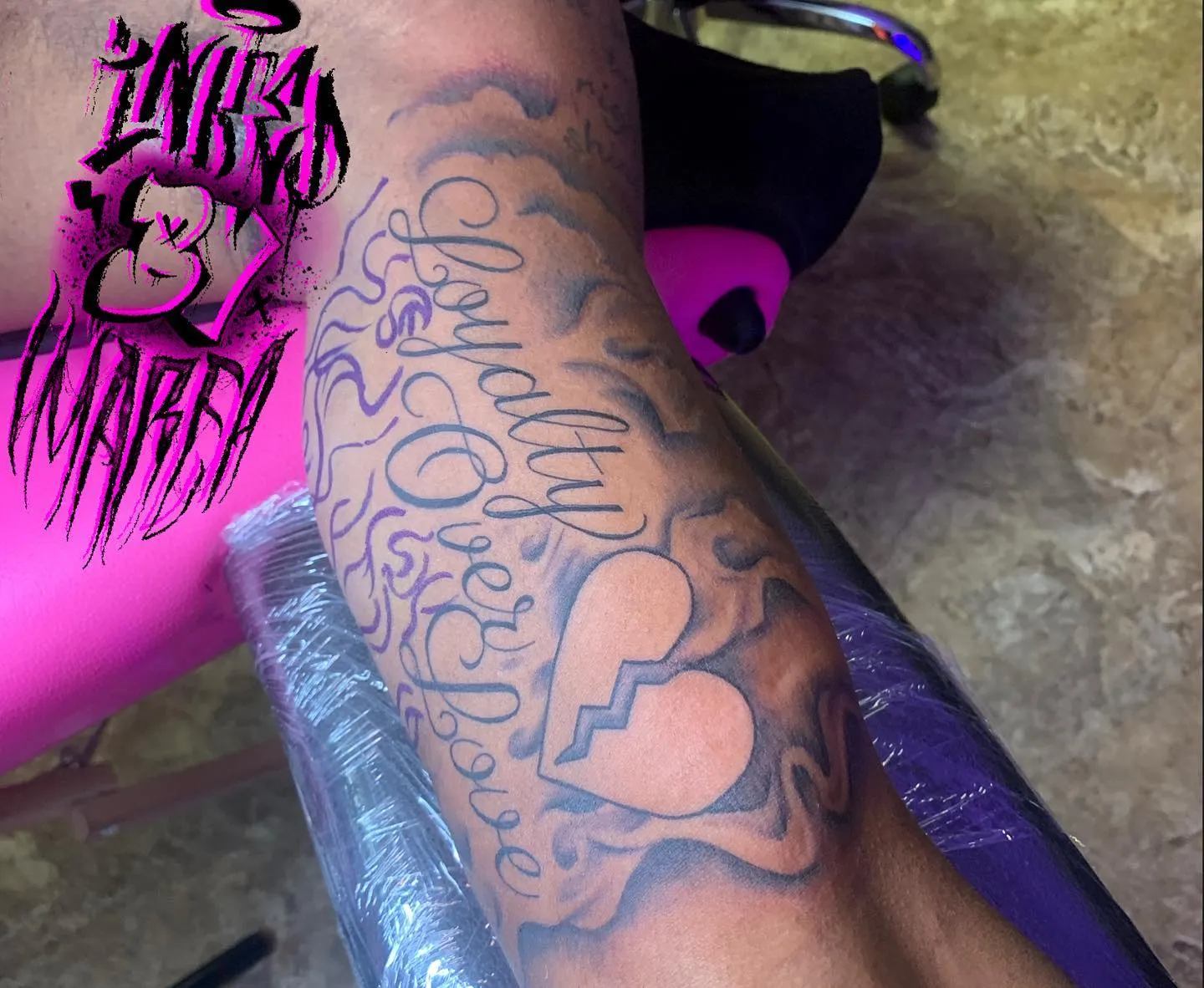 Intricate loyalty over love script on forearm