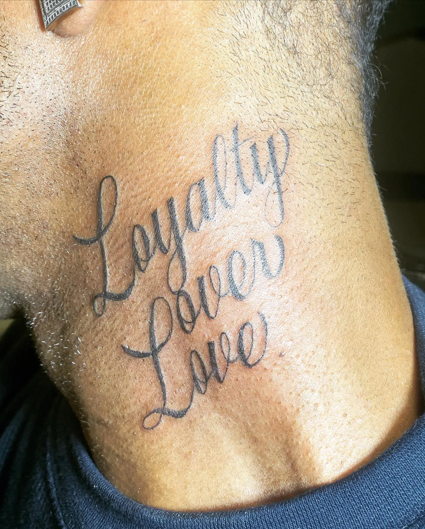 Loyalty Over Love Written in a Casual Script Neck Tattoo