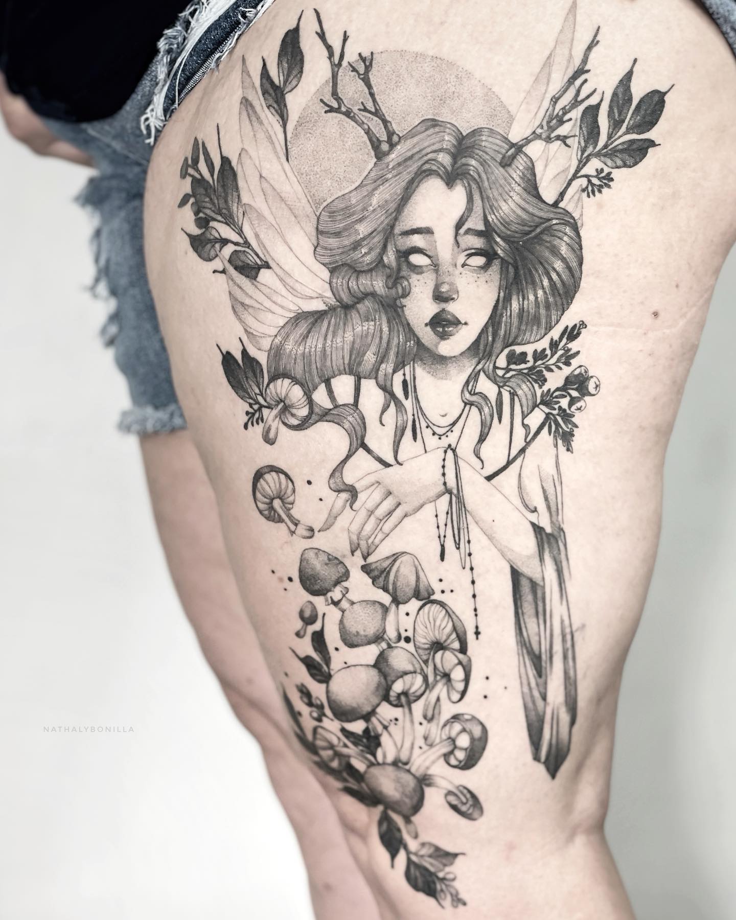 Mystical fairy and flora thigh tattoo