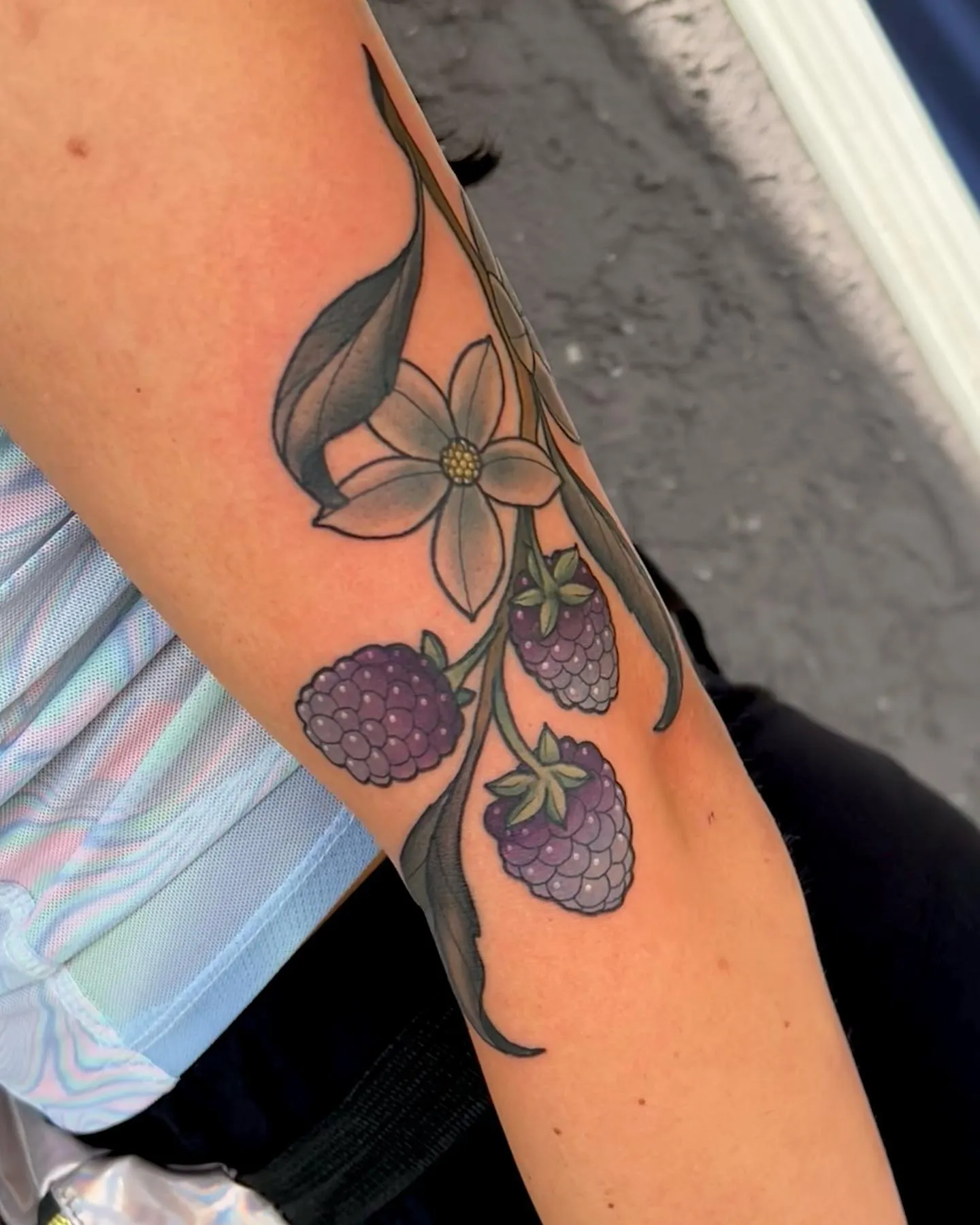 Purple-toned blackberries with blossom arm tat