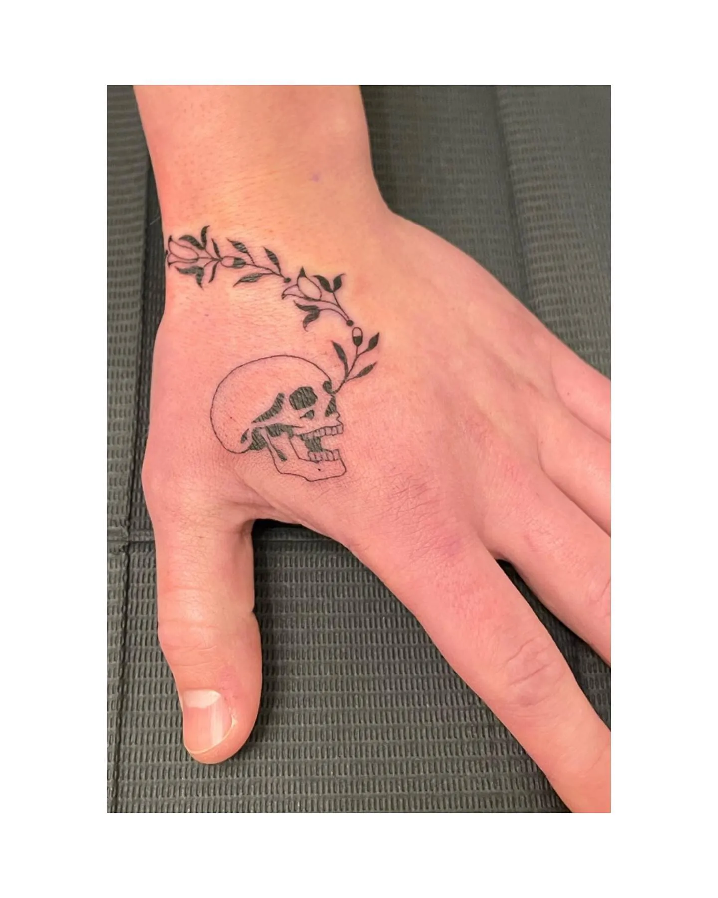 Skull Adorned with Leafy Vine Side Hand Tattoo