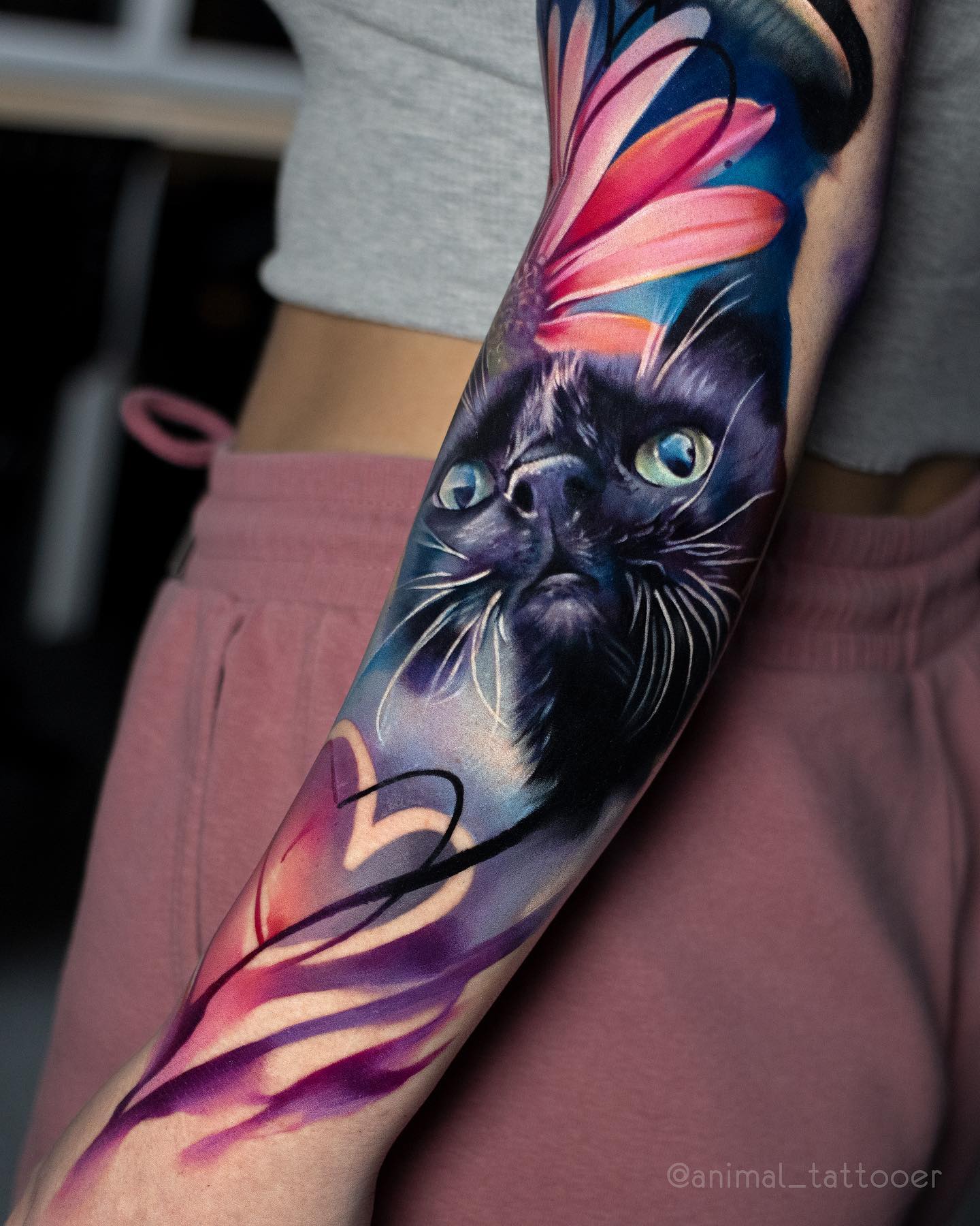 Vibrant Cat Tattoo with Floral Elements on Forearm