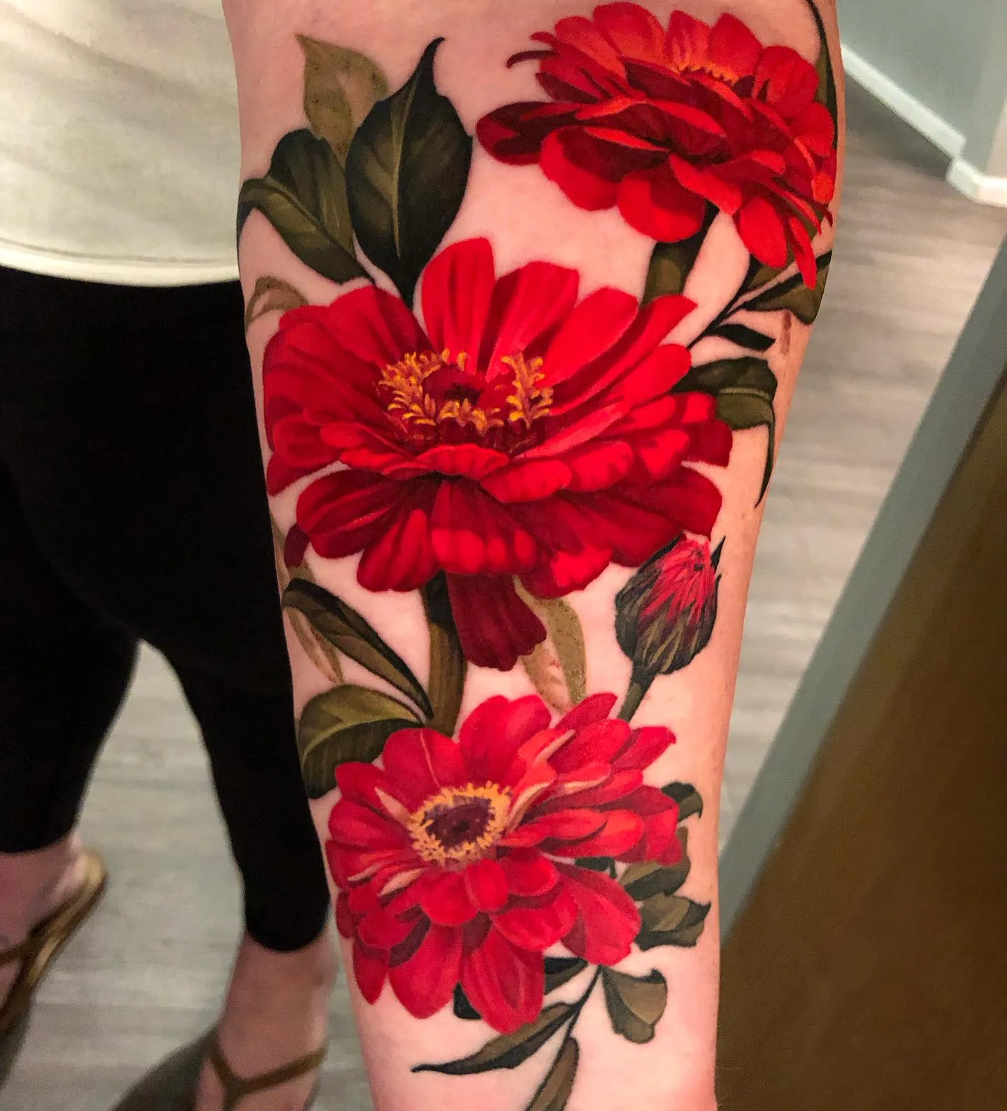 Vibrant Red Zinnia Tattoo Wrapped Around Arm