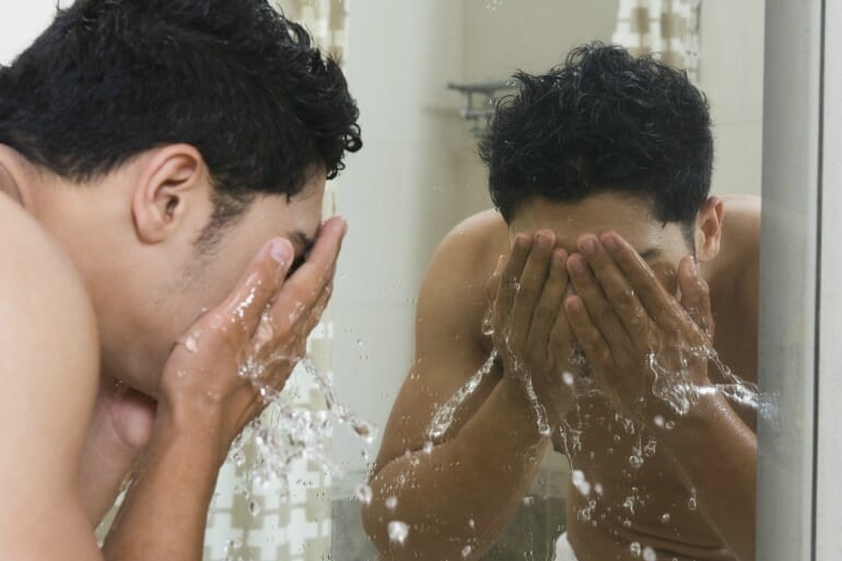 man washing face water skin bathroom clear skin