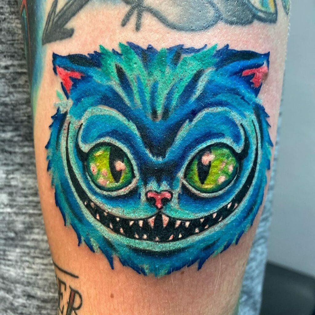 Blue Cheshire Cat Upper Arm Tattoo