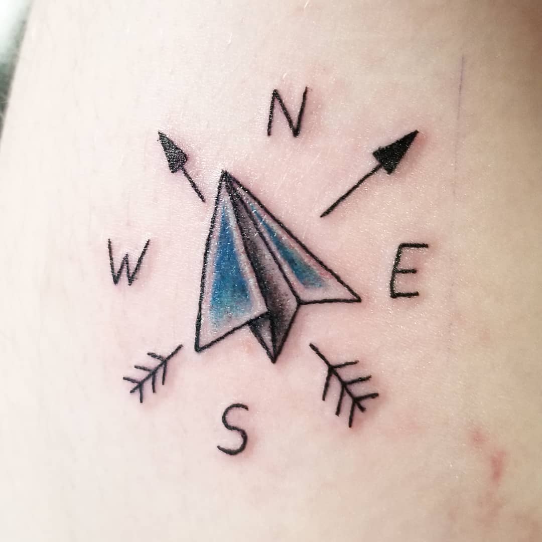 Minimalistic style paper plane and wave tattoo located