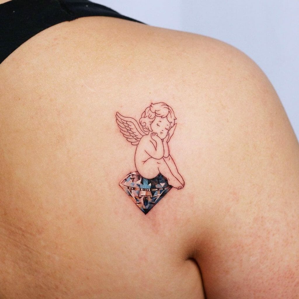 Baby Angel Sitting On A Diamond Tattoo