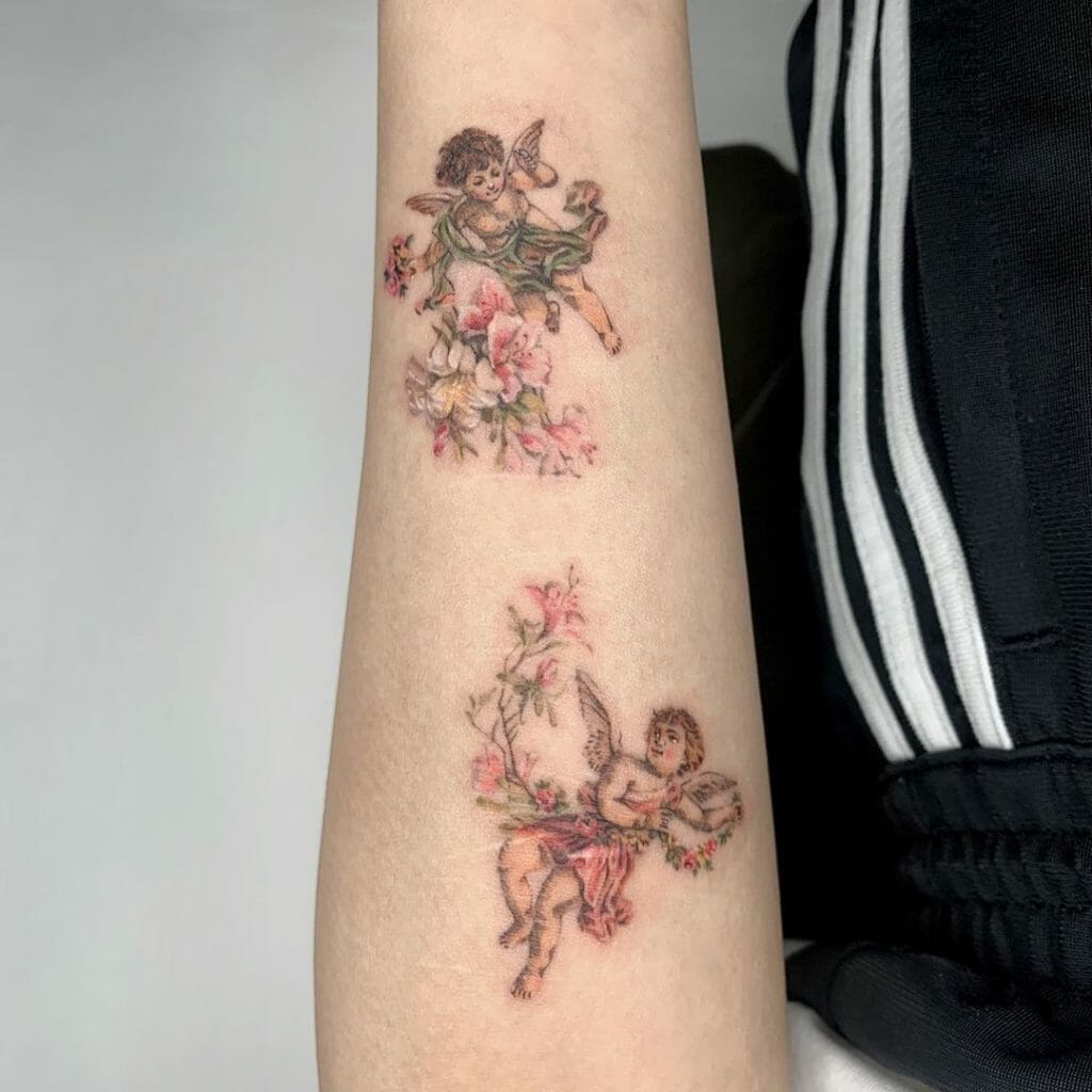 Two Baby Angels With Floral Design Tattoo