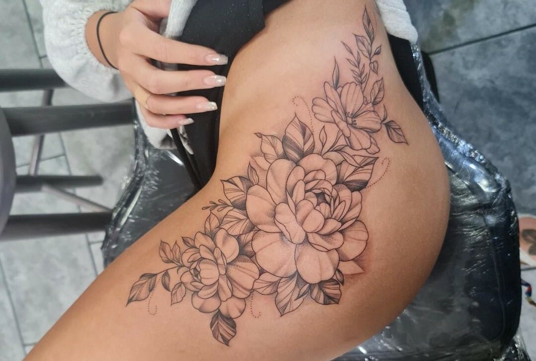 Fine line flower tattoo on the hip