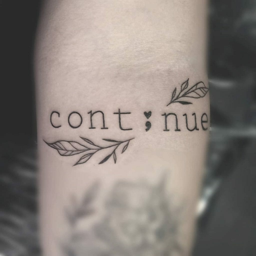 A Continue Tattoo With Leaves