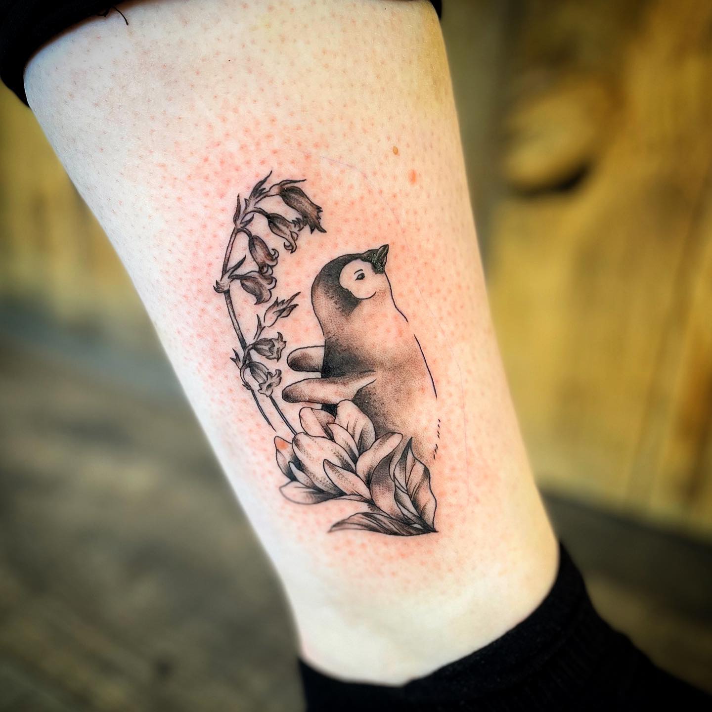 Tiny penguin tattoo on the bicep
