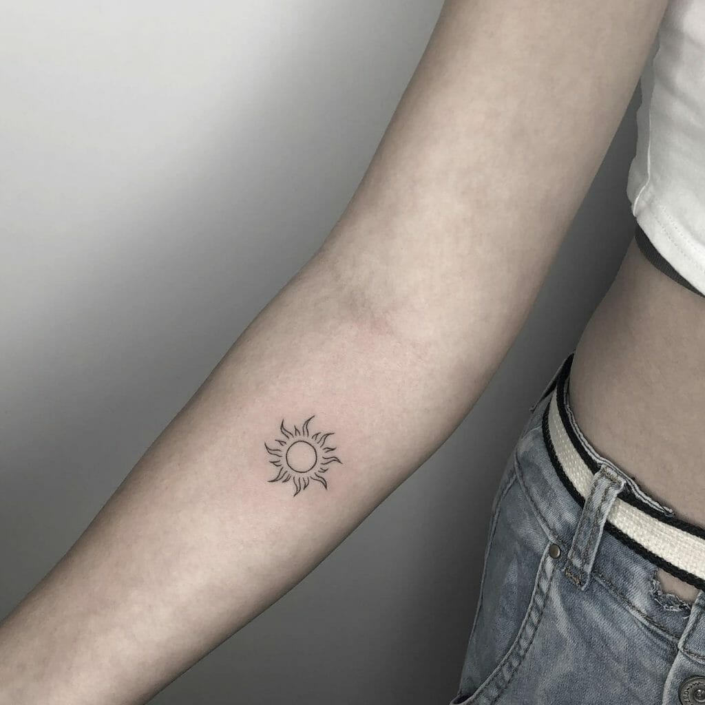 Minimalist sun tattoo on the tricep