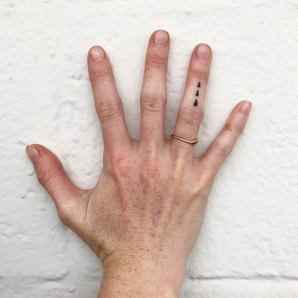Teardrop minimalistisches Tattoo an den Fingern