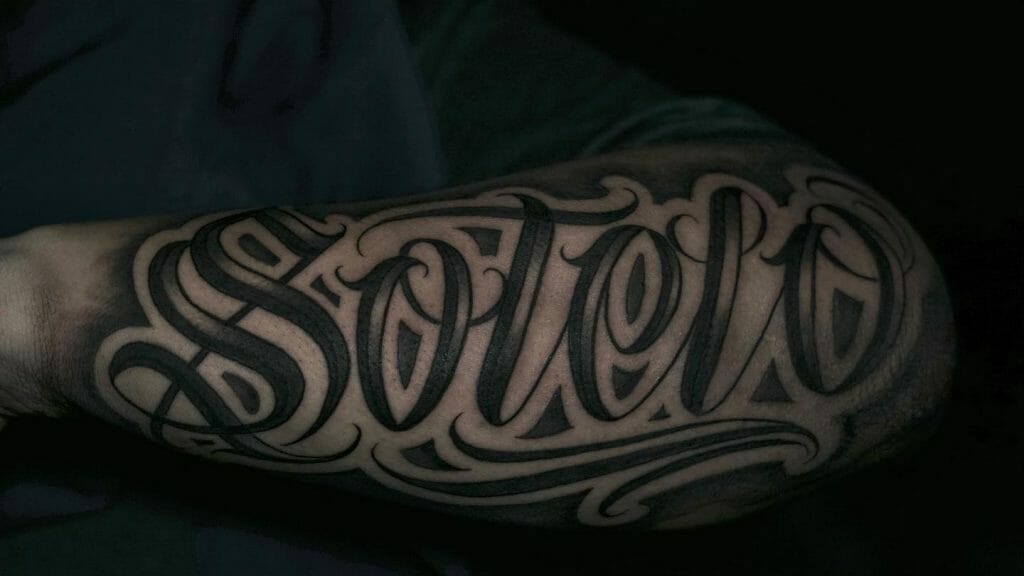  Stylish Last Name Tattoo In Black On Arm