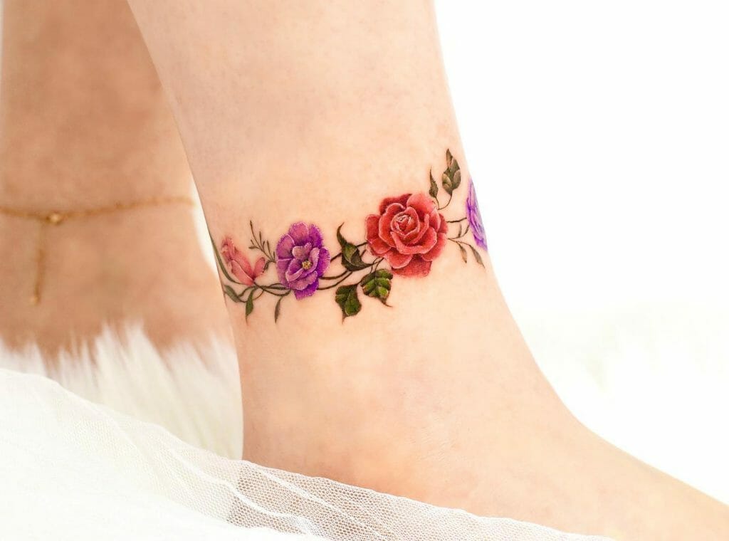 A Flower Anklet Tattoo of Roses With Green Leaves