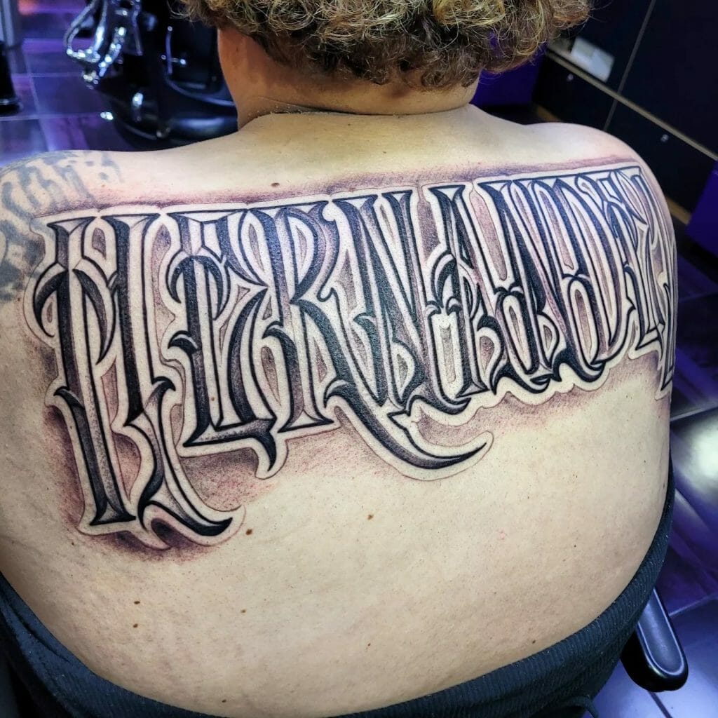  Last Name Tattoo In Black And Grey On Back