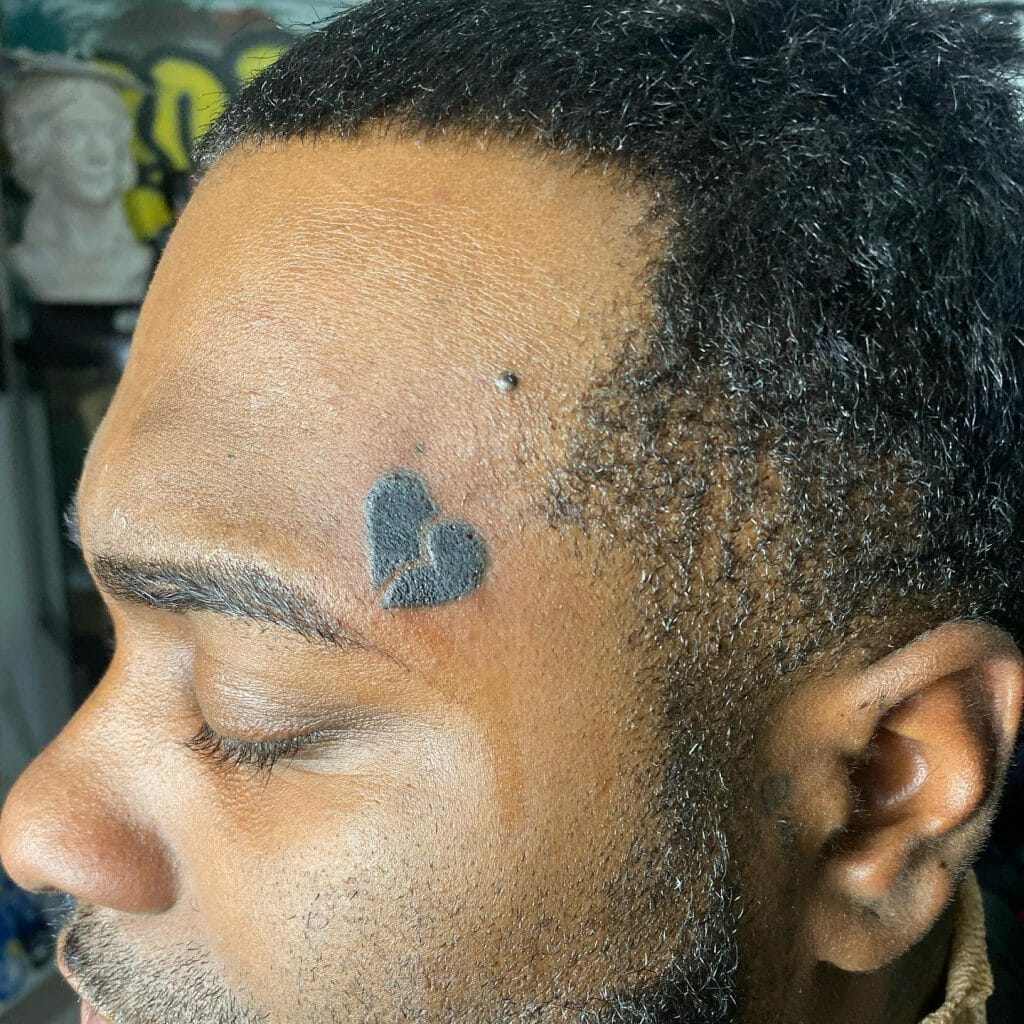 Black Broken Heart Tattoo On Forehead