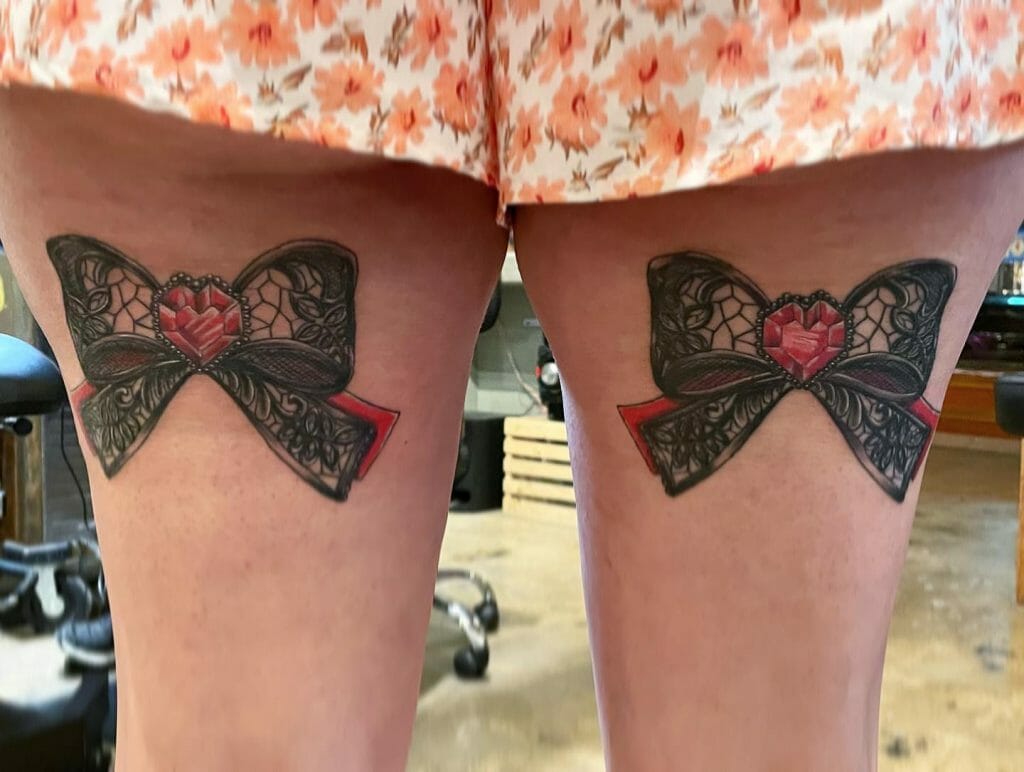 Ruby And Bow Both Thigh Tattoo