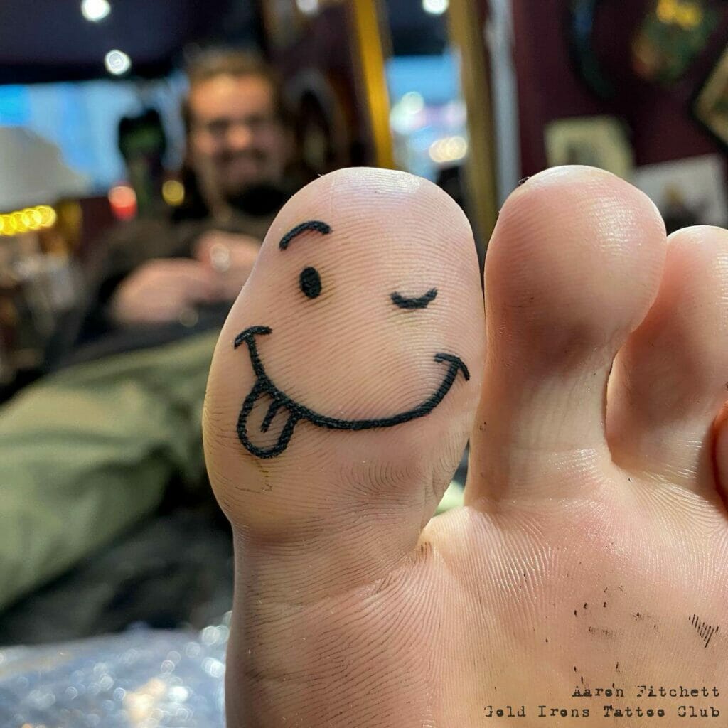 Adorable Smiley Tattoo On Toes