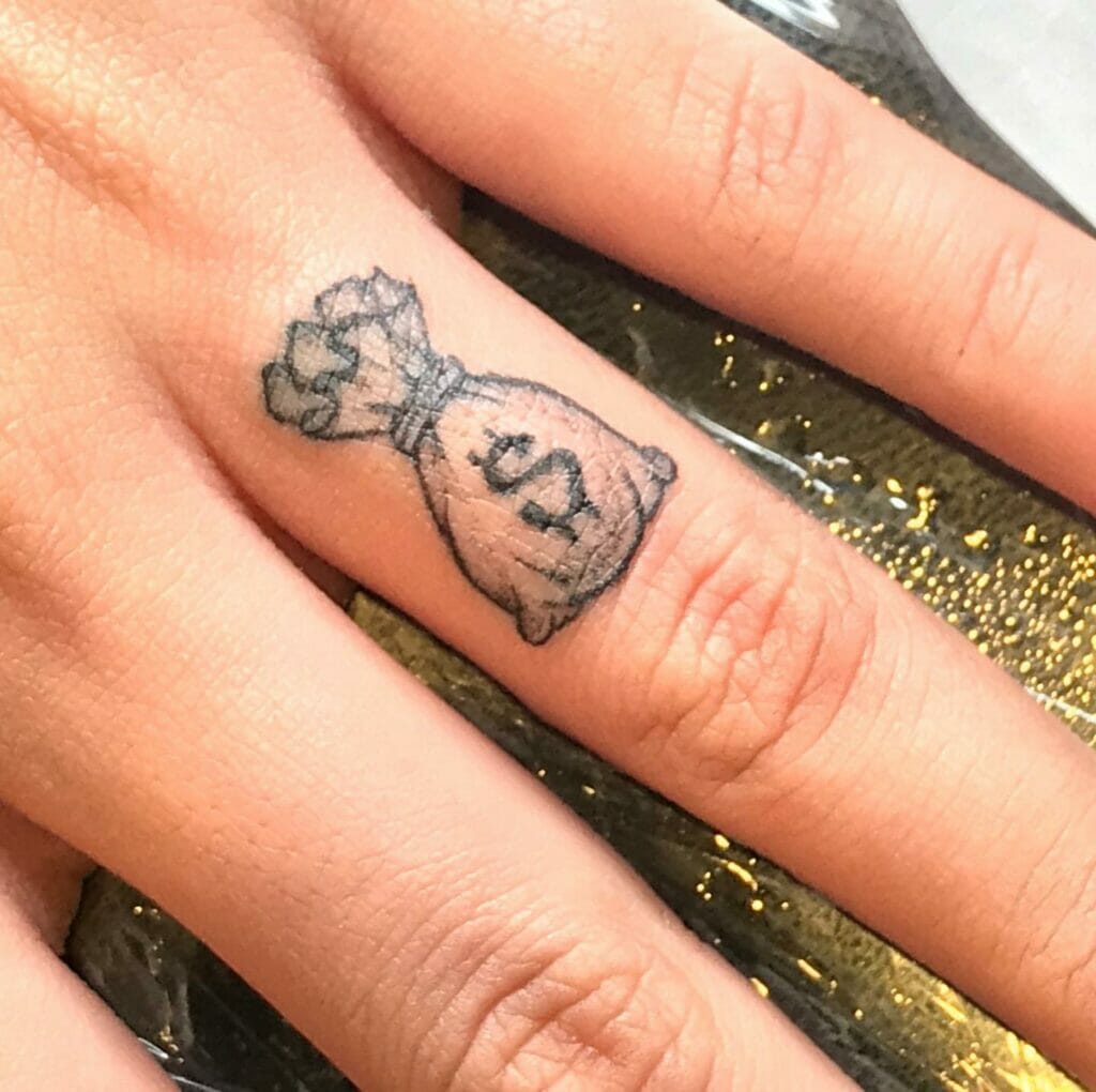 Money Bag Tattoo Design On Finger For Women