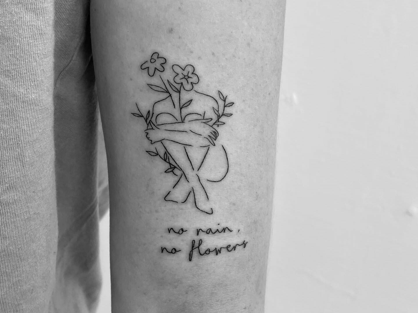 No rain no flowers lettering tattoo on the top of the