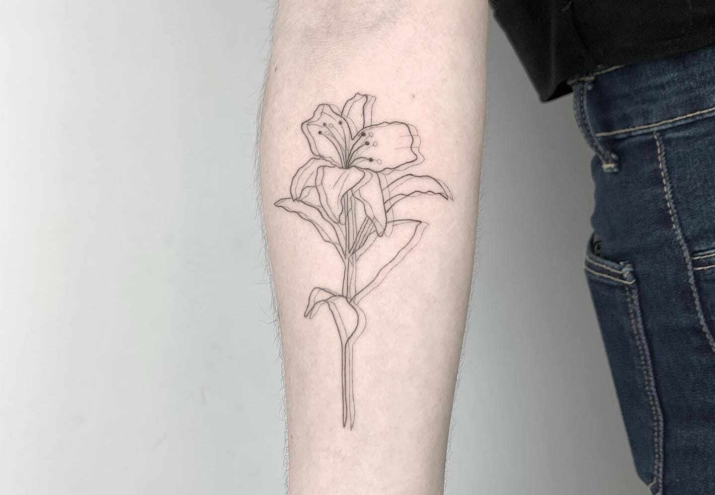 Fine line lily flower tattoo on the ankle