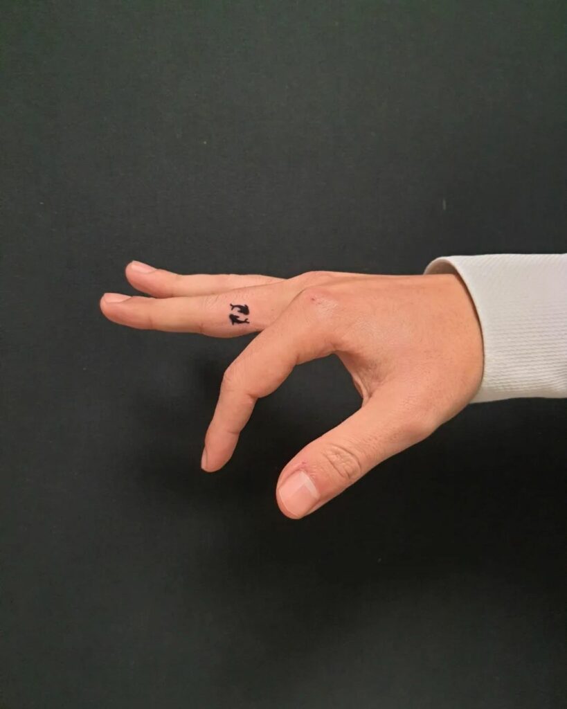 Minimalist Fish Inner Finger Tattoo