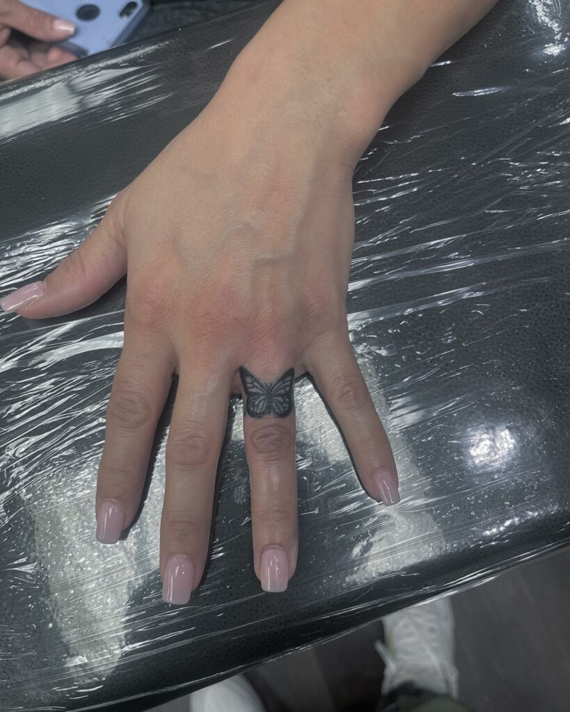 Petit tatouage de doigt d'anneau de papillon pour des femmes